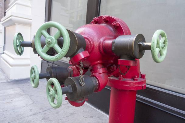 Bouche d'incendie complexe rouge avec 5 vannes vert clair
 - Photo, image