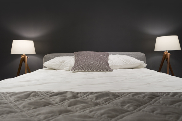 cama con almohadas y luces de cama
 - Foto, Imagen