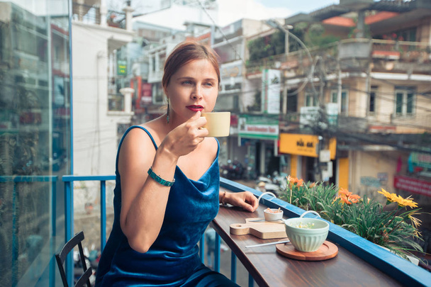Beautiful woman enjoying tea on cafe terrace - Fotó, kép