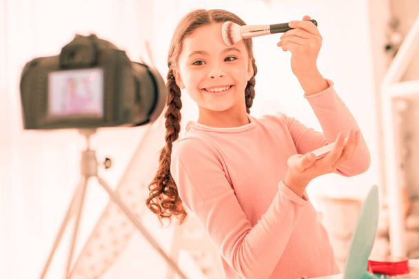 Delighted positive girl using her makeup tools - Zdjęcie, obraz