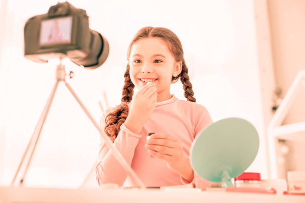 Joyful happy girl applying lipstick on her lips - Valokuva, kuva