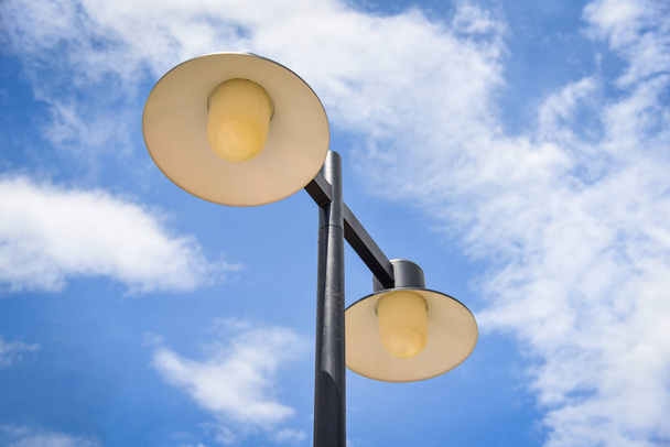lantaarnpaal op blauwe hemelachtergrond / Light lamp hangen op de paal - Foto, afbeelding