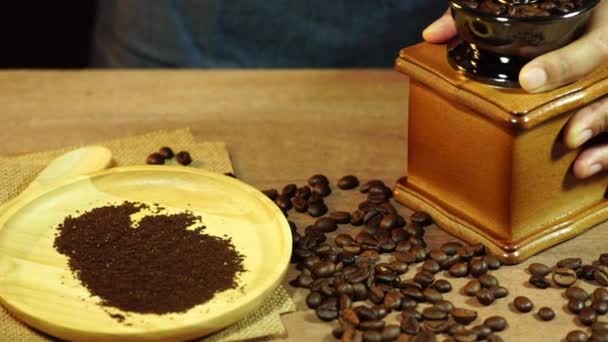 Pan and slow motion women's hands are grinding coffee beans on a wooden table. - Filmmaterial, Video