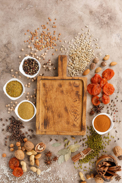 Dried fruits spices cereals and nuts organic healthy snacks on a textural background. Decorative board. Frame for the text.Copy space. - 写真・画像