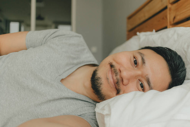 Close up man sleeping on his bed with happy smile face. Concept of happy deep sleep. - Fotó, kép