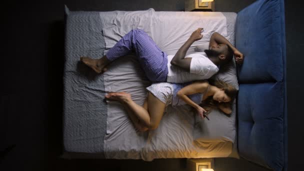 Couple avec téléphones intelligents couchés dans le lit dos à dos
 - Séquence, vidéo