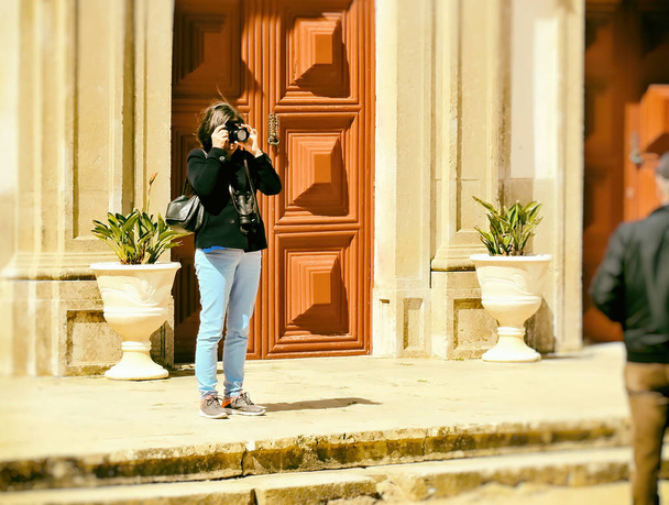 Γυναίκα φωτογράφηση κοντά σε μια πύλη - Φωτογραφία, εικόνα
