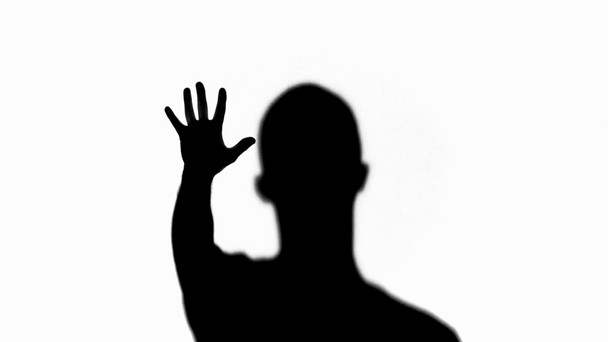 Foco selectivo de silueta del hombre mostrando la palma y desapareciendo aislado en blanco
 - Imágenes, Vídeo