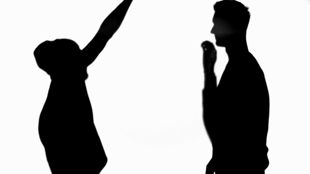 Vista lateral de siluetas de dos amigos mostrando alto cinco signo aislado en blanco
 - Metraje, vídeo