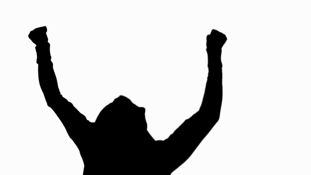 silhouette of excited man in hood showing yes gesture isolated on white - Filmati, video
