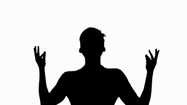 Front view of silhouette of man meditating and showing mudras isolated on white - Footage, Video