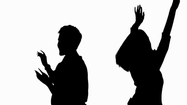 Two silhouettes of happy women waving hands and dancing isolated on white - Footage, Video