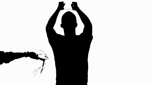 Częściowy widok sylwetki kobiety z chłosta bicz pokonując mężczyznę w kajdankach na białym tle - Materiał filmowy, wideo