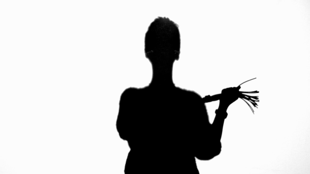 Vista frontal de la silueta de la mujer sosteniendo látigo azotes aislados en blanco
 - Imágenes, Vídeo