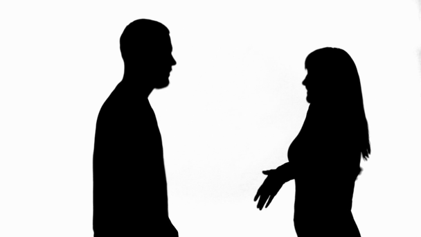 Seitenansicht von zwei Silhouetten eines sich streitenden und winkenden Paares isoliert auf weißem Grund - Filmmaterial, Video