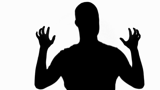 Silhouette of man slowly scratching isolated on white - Materiał filmowy, wideo