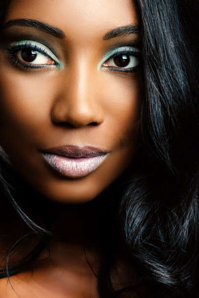 Macro primer plano foto de la cara de la joven africana con expresión facial sensual y largo peinado rizado negro
.  - Foto, imagen