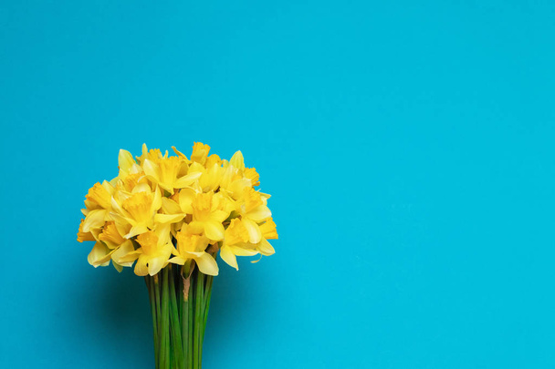 Bouquet of fresh yellow daffodils, blank holiday card with flowers. flat lay - Zdjęcie, obraz
