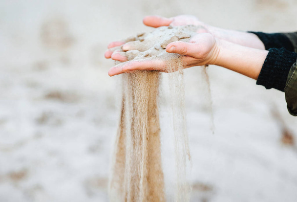 A handful of sand is poured through your fingers. Time flow. Archeology. Mystery of the past. - Foto, Imagem