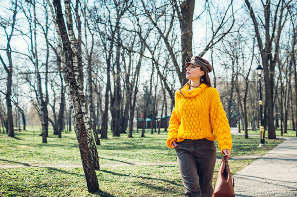 Young woman holding stylish handbag and wearing yellow sweater. Spring female clothes and accessories. Fashion - Foto, immagini