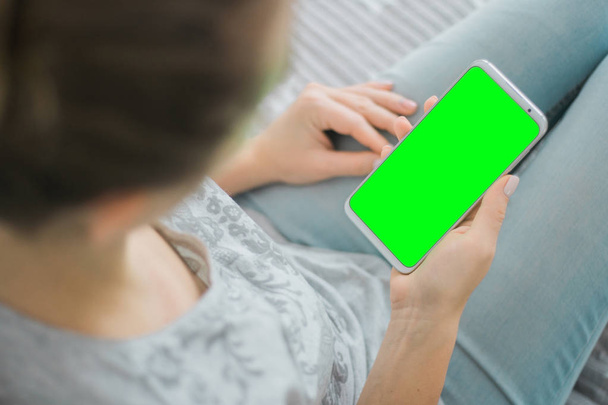 Green Screen Smartphone. Die Hände der Frau halten ein Handy-Attrappen-Bild. Chroma-Schlüssel. Nahaufnahme. - Foto, Bild