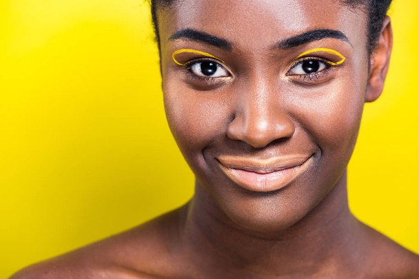 Vista ritagliata di allegra donna africana americana sorridente alla fotocamera sul giallo
 - Foto, immagini