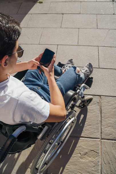 携帯電話を使った車椅子の若者の肖像 - 写真・画像
