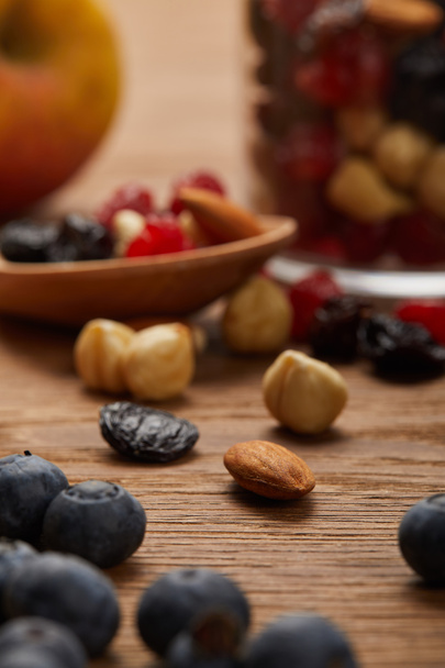 close up of blueberries and nuts on wooden table - Foto, afbeelding