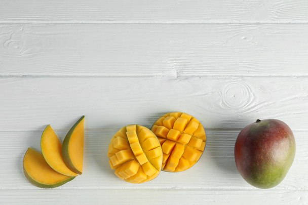 Plat lag samenstelling met gesneden rijpe mango's op witte achtergrond,  - Foto, afbeelding