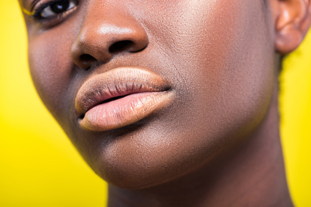 Cropped view of beautiful african american woman isolated on yellow - 写真・画像