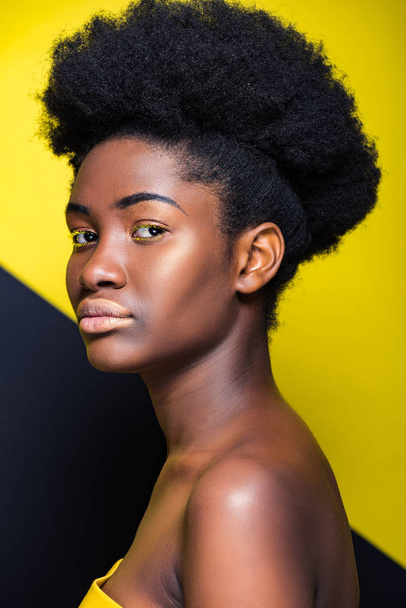 Attractive african american girl looking at camera on black and yellow - Foto, Imagem