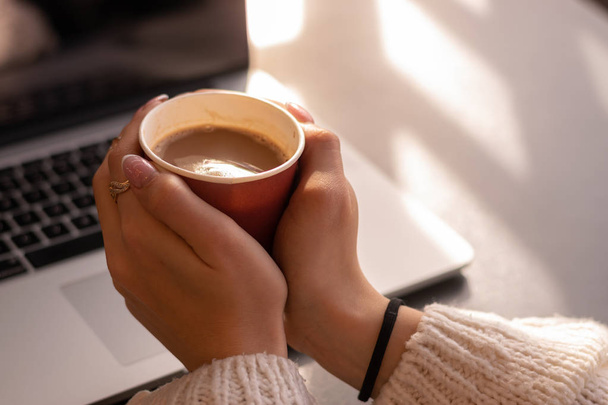 cropped shot of woman holding cup of coffee at workplace - Фото, зображення