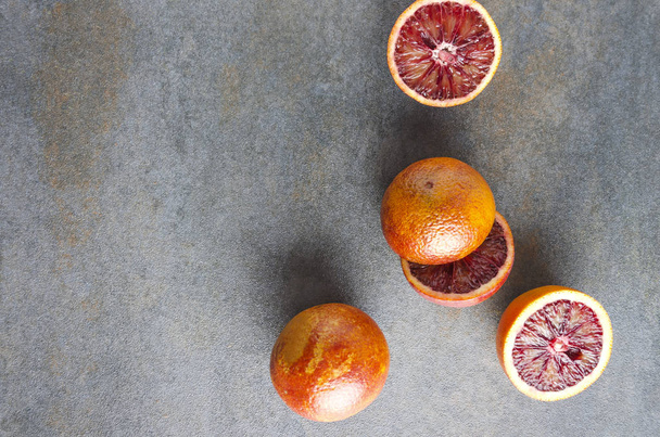 Top view of sicilian fruits.Whole and halves blood oranges on dark surface - Photo, image