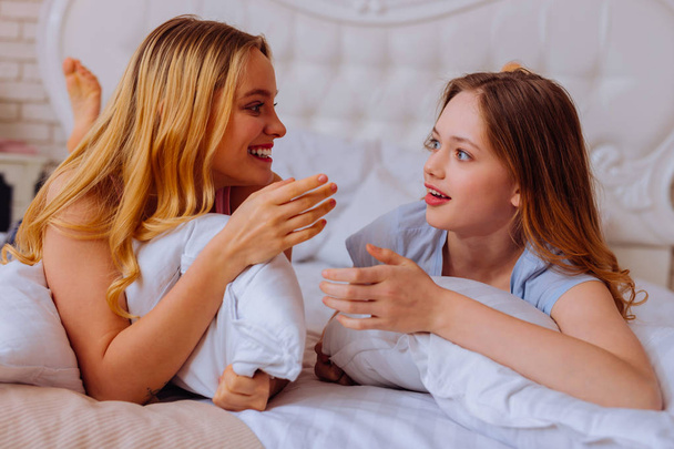 Older and younger sisters feeling emotional discussing boyfriends - Фото, изображение