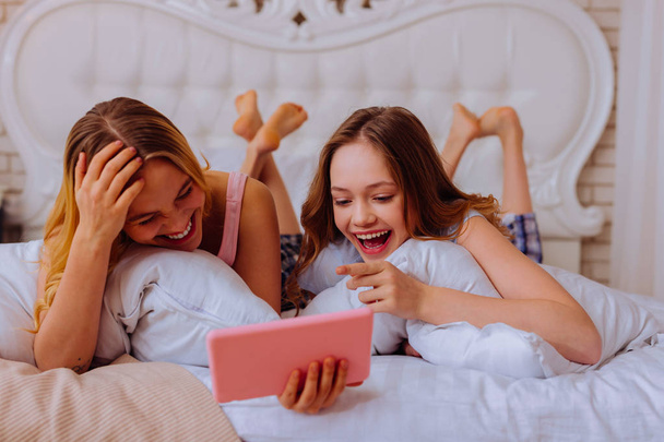 Sisters laughing out loud after watching funny video - Foto, Bild