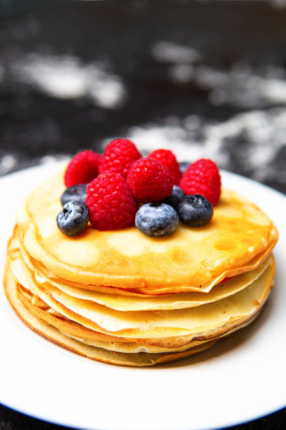 Photo of plate with pancakes, blueberries, raspberries. - Фото, зображення