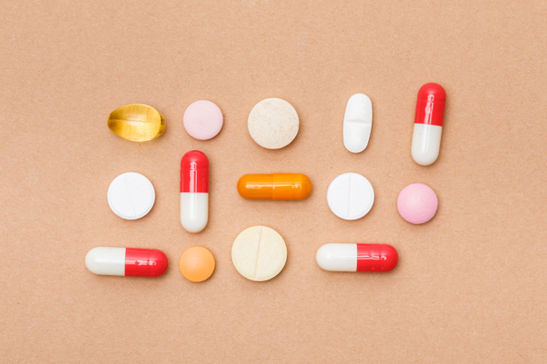 Top view of colorful pills on brown surface - Foto, afbeelding