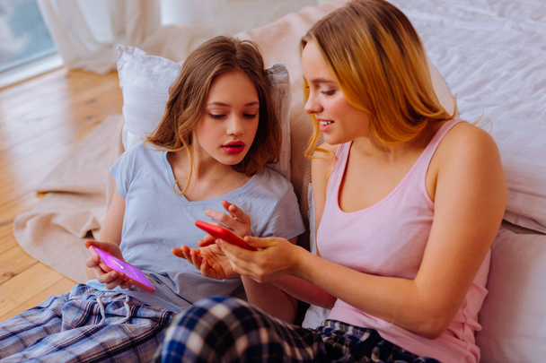 Sisters wearing pajamas shopping online at the weekend - Foto, immagini