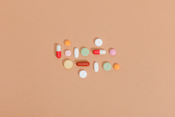 Top view of colorful pills on brown surface - Fotó, kép