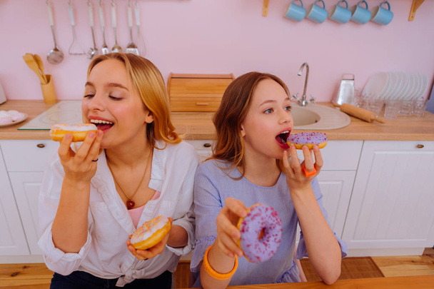 Siblings trying sweet doughnuts in the morning at the weekend - Foto, Imagem