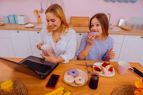 Freelancer enjoying family breakfast with her teenage sibling - Fotoğraf, Görsel