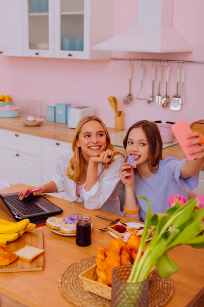 Mädchen hält Smartphone während Selfie mit älterer Schwester - Foto, Bild