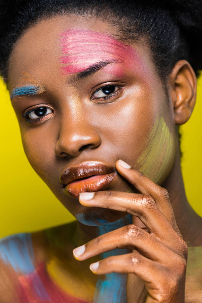 Pensive african american girl with body art touching lips isolated on yellow - Fotoğraf, Görsel