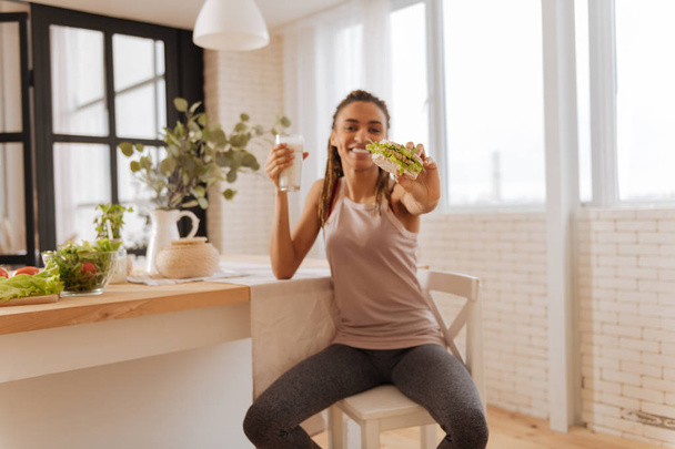 Жінка в легінсах і спорті, насолоджуючись здоровою закускою
 - Фото, зображення