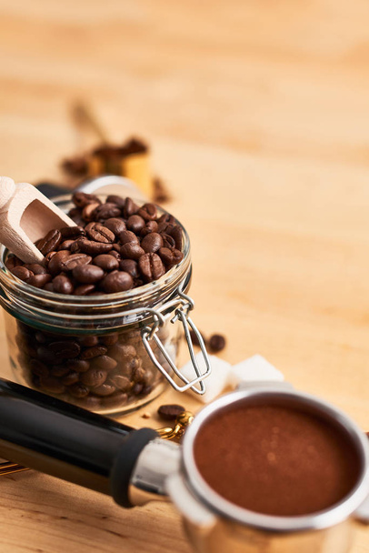 Freshly roasted coffee beans in a glass jar and portafilter - Foto, Bild