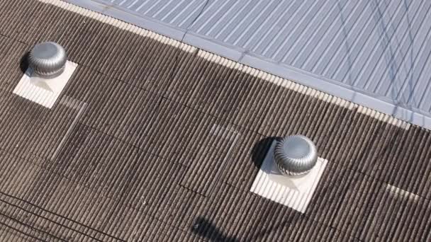 Spinning turbine ventilatoren werken op het dak en de schaduw van de vogel vliegen van boven - Video