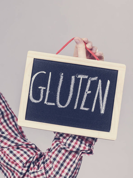 Woman holding board with gluten sign - Foto, Imagen