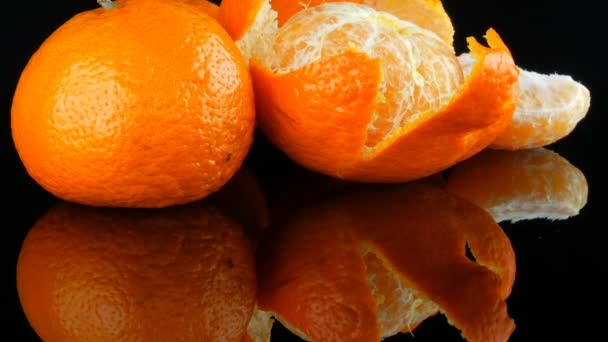 Las frutas mandarina sobre el fondo negro sobre la superficie del espejo
 - Metraje, vídeo