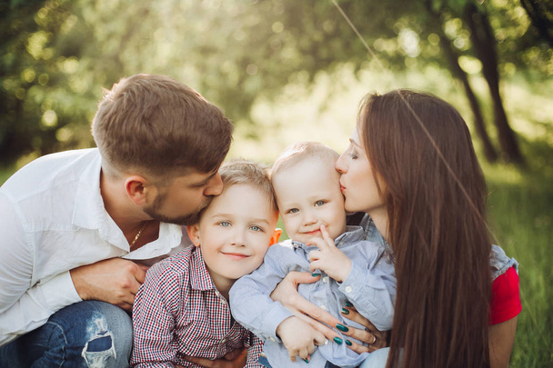 Πορτρέτο των νέων ευτυχισμένη οικογένεια φιλιά τον μικρό γιο του. - Φωτογραφία, εικόνα