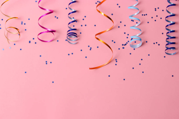 Festive background of ribbons and confetti on a colored background top view. - Foto, afbeelding